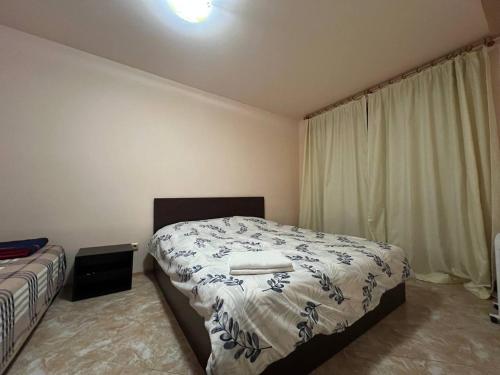 a bedroom with a bed and a window with curtains at VIGO Nessebar in Nesebar