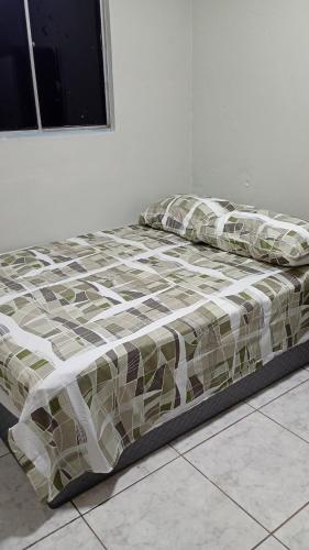 a bed in a white room with a bedspread and pillows at Apartamento Completo e Centralizado 4 in Belém