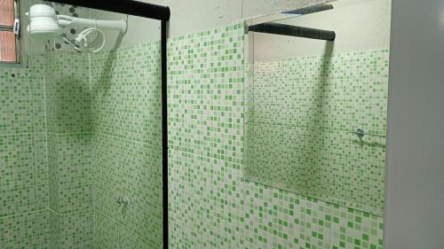 a bathroom with green tiled walls and a glass shower at Apartamento Completo e Centralizado 4 in Belém