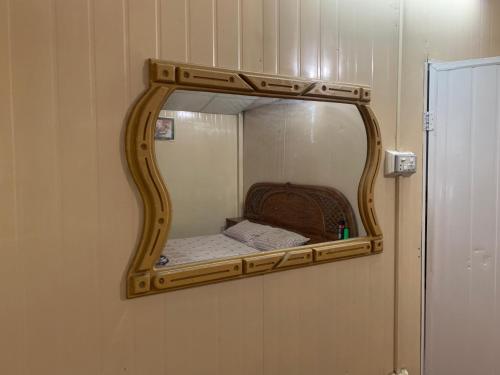 a mirror on a wall with a bed in it at Private Retreat in Muzaffarabad