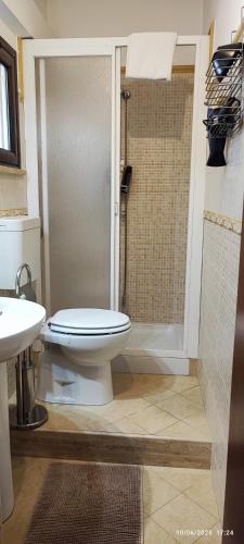 a bathroom with a toilet and a shower and a sink at casa Fontana in Capaci