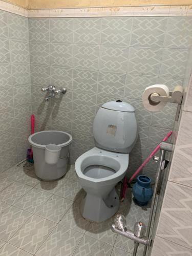 a bathroom with a toilet in a tiled wall at Private Retreat in Muzaffarabad