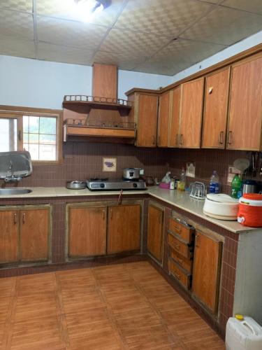 a kitchen with wooden cabinets and a counter top at Private Retreat in Muzaffarabad