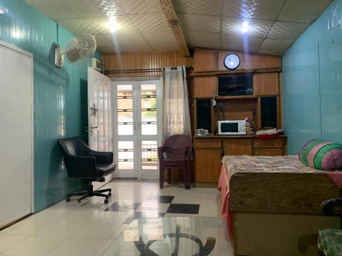 a bedroom with a bed and a desk and a microwave at Private Retreat in Muzaffarabad