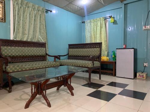 a living room with two benches and a glass table at Private Retreat in Muzaffarabad