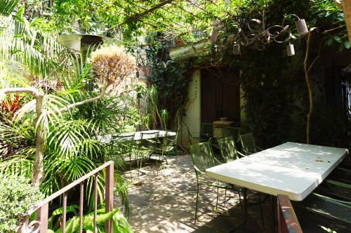 un patio con mesa y sillas en un jardín en Enjoy AC in Our Guest Room at Inn Ajijic, en Ajijic