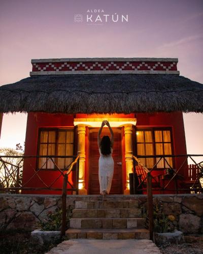 a house with a statue of a person standing in front of it at Hotel Aldea Katún in Izamal