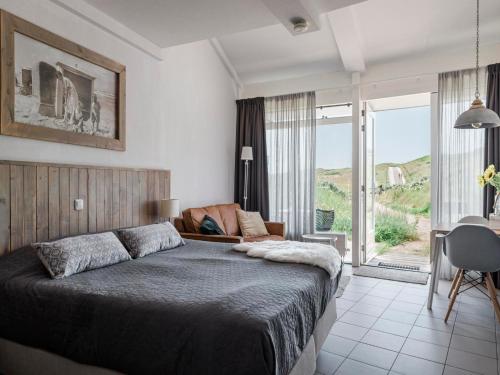 a bedroom with a large bed and a large window at Seaside Double Duyn Suites in Callantsoog