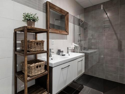 a bathroom with a white sink and a shower at Seaside Double Duyn Suites in Callantsoog