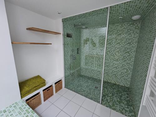La salle de bains est pourvue d'une douche avec du carrelage vert. dans l'établissement Maison d'architecte 9p - 400m de la mer & du bourg, à Santec