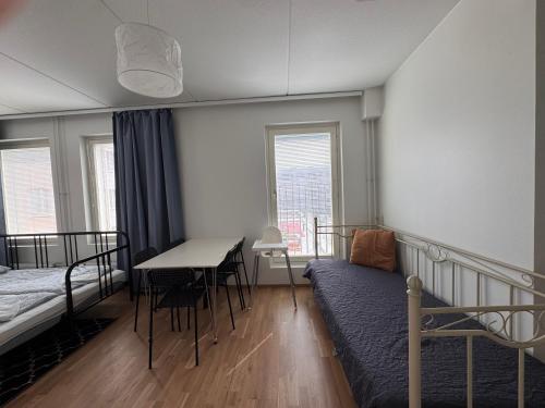 a bedroom with a bed and a table and a desk at Transit Apartments HEL Airport in Vantaa