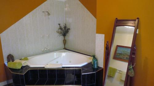 a bathroom with a bath tub in a room at Gumtree on Gillies Bed and Breakfast in Yungaburra