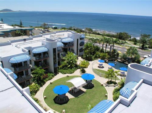 an aerial view of a resort with blue umbrellas at Headland Tropicana Resort in Alexandra Headland