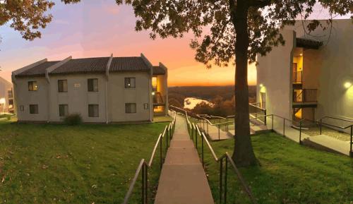 a house with a tree next to a building at Lake Ozark-1bd1ba-hippo Pool, Regalia Resort in Lake Ozark
