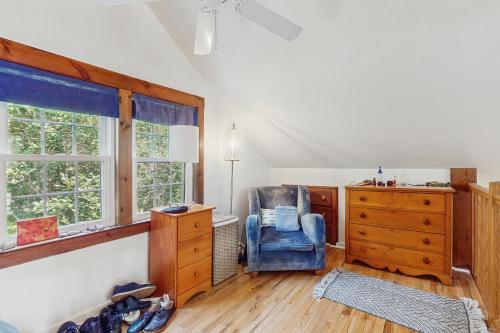 Habitación con silla, cómoda y ventanas en The Lodge, en Provincetown