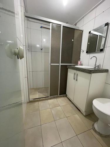 a bathroom with a shower and a toilet and a sink at Apartamento 05 - Um quarto, sala e cozinha in Balneário Camboriú