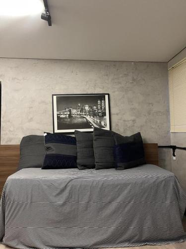 a bedroom with a bed with a picture on the wall at Apartamento 05 - Um quarto, sala e cozinha in Balneário Camboriú