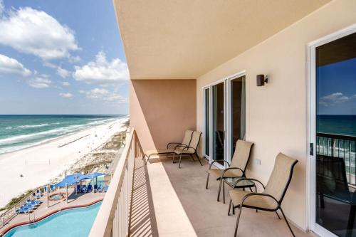 een balkon met stoelen en uitzicht op het strand bij Sunrise Beach 906 -Beachfront Condo in Panama City Beach