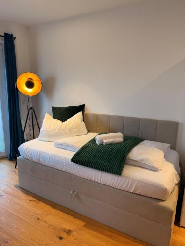 a bed in a room with a lamp and a bedvisor at 90m2 Loft I Kaffee I Terrasse I E-Parkplatz I 65' Smart TV in Rosenheim