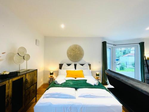 a bedroom with a large bed and a window at 90m2 Loft I Kaffee I Terrasse I E-Parkplatz I 65' Smart TV in Rosenheim