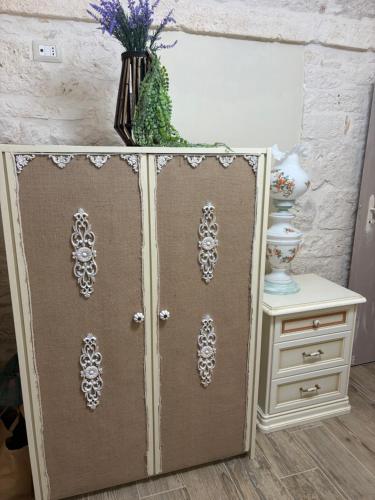 a cabinet with a door with a vase on top at La casa di nonna Marta in Martina Franca