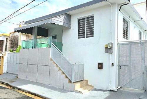 a white house with a staircase in front of it at Humacao - Apart, Super Central, AC, TV, Wifi, Fully Equipped in Humacao