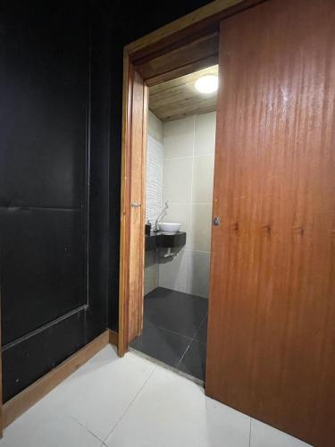 bagno con lavandino e porta in legno di Suíte com Hidro no centro a Balneário Camboriú