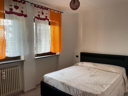 a bedroom with a bed and two windows at cozy house in Olgiate Comasco in Olgiate Comasco