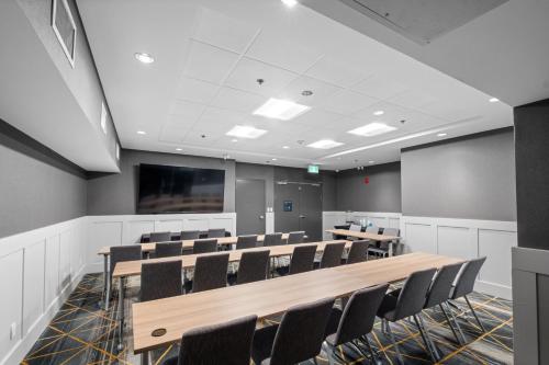 a conference room with tables and chairs and a screen at Holiday Inn Hotel & Suites Surrey East - Cloverdale by IHG in Surrey