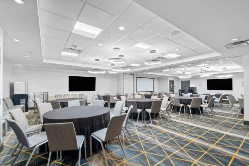 a conference room with tables and chairs and screens at Holiday Inn Hotel & Suites Surrey East - Cloverdale by IHG in Surrey