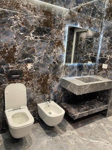 a bathroom with a toilet and a sink and a mirror at Stone Bazaar Villa in Krujë