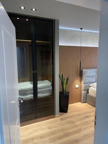 a bedroom with a glass door with a bed in it at Stone Bazaar Villa in Krujë