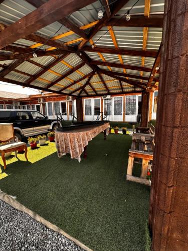 a covered patio with a ping pong table in it at Дос in Kapchagay