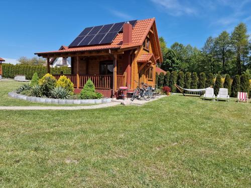 a cabin with a solar roof on a lawn at Żuraw in Wyszowate
