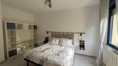 a bedroom with a bed with white sheets and a window at Jazz Loft in Perugia