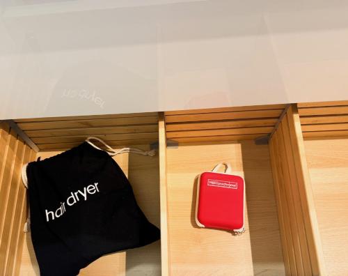 a black shirt and a red suitcase in a drawer at L Écrin de Neuilly - La Défense & Champs Elysées 10 min away in Neuilly-sur-Seine