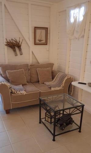 a living room with a couch and a glass table at Les Gîtes de Bergette in Petit-Bourg