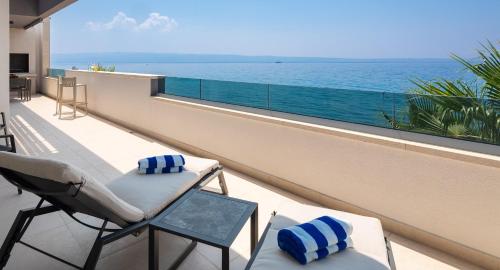 a balcony with chairs and a view of the ocean at Paoma Luxury Beach Suite with jacuzzi in Podstrana