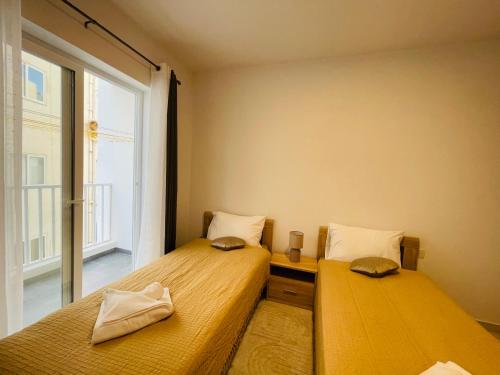 two beds in a room with a window at See You 4 Diego Court in St Paul's Bay