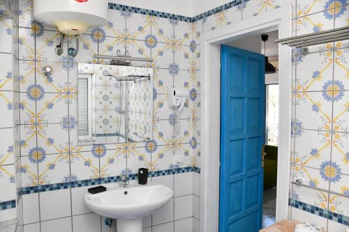 a bathroom with a sink and blue and yellow tiles at Fantasy House Apartaments in Forio d'Ischia
