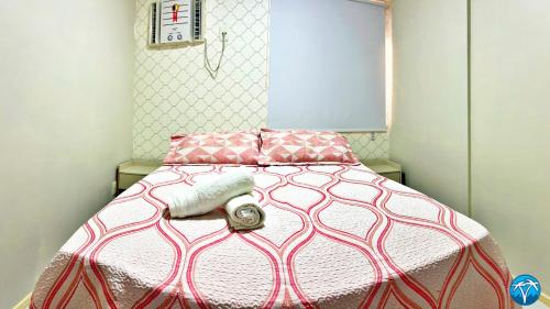 a bed with a pink and white blanket on it at Vacanze - Barão de Mauá in Maceió