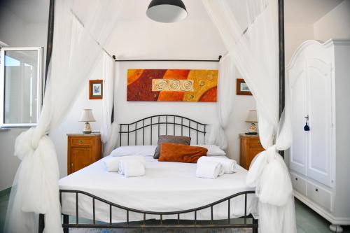 a bedroom with a bed with white curtains at Fantasy House Apartaments in Forio d'Ischia