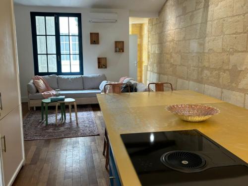 a kitchen and living room with a couch at Grand appartement climatisé en plein centre de Bordeaux Place Fernand Lafargue in Bordeaux
