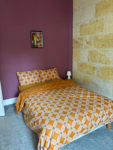 Ce lit se trouve dans une chambre dotée d'un mur en briques. dans l'établissement Grand appartement climatisé en plein centre de Bordeaux Place Fernand Lafargue, à Bordeaux