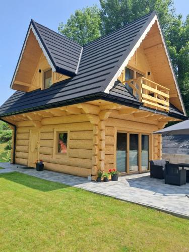 a log cabin with a black roof at Domek z bali Zakopane in Zakopane