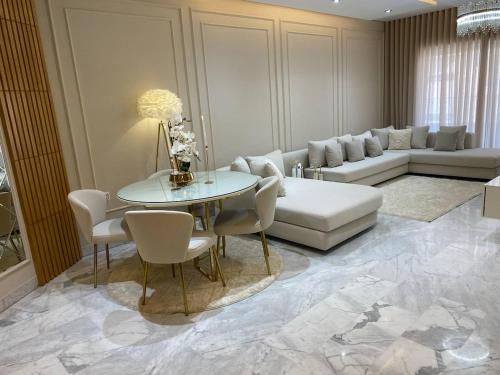 a living room with a couch and a table and chairs at Luxury Apartment two bedroom - sea view - best spot in sousse in Sousse