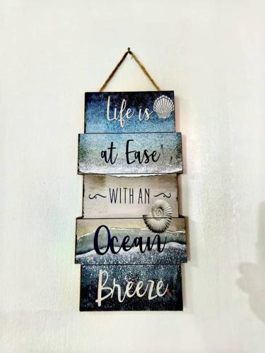 a sign that reads life is at ease with an ocean breeze at Condo by the Beach Port Dickson - Forest & Poolview in Port Dickson