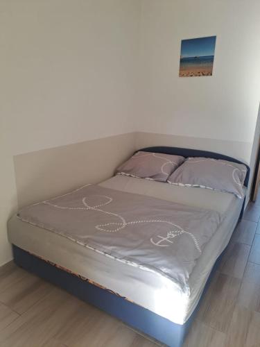 a bed with two pillows and a bed frame at Studio Apartments Trio in Šmrika