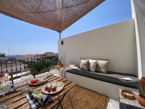 a room with a bed and a table on a balcony at Casa Amanhada Apartamento Um in Grândola
