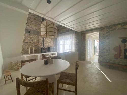 a dining room with a white table and chairs at Casa Amanhada Apartamento Um in Grândola